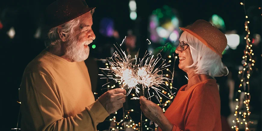 Älteres Paar feiert Silvester mit Wunderkerzen