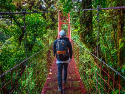 Mann geht allein auf einer Hängebrücke im Nebelwald von Monteverde in Costa Rica