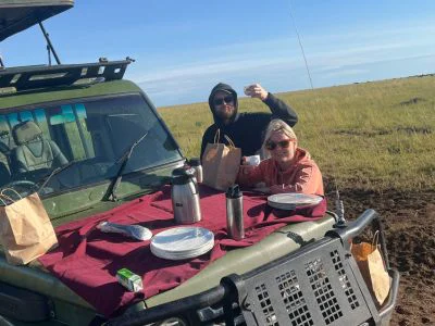 Zwei Personen frühstücken im Safarifahrzeug